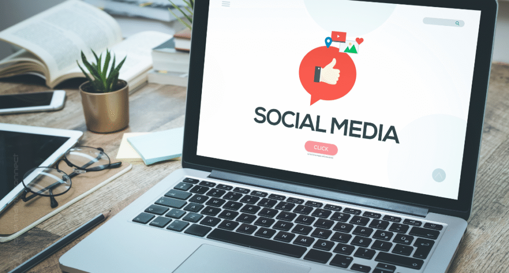 Laptop screen showing 'Social Media' icon with desk items, concept of social media marketing, engagement, and online branding.
